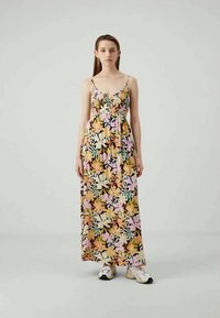 Maxi-jurk met een bloemenpatroon in roze, geel en groene tinten. Gemaakt van lichte stof met verstelbare spaghettibandjes.