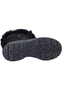 Svart mocka stövel med foder i päls, med en texturerad gummiyttersula som har ett greppvänligt mönster för bra fäste.
