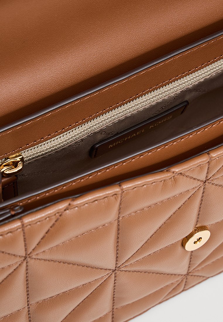 Borsa a tracolla in pelle marrone con motivo trapuntato, dotata di tasca interna con cerniera e hardware in tonalità dorata. Etichetta del marchio visibile all'interno.