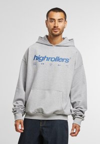 Szürke pamut kapucnis felső, nagy kék "highrollers" logóval. Elöl zsebe van, széles ujjai vannak, és húzózsinóros kapucnival rendelkezik.