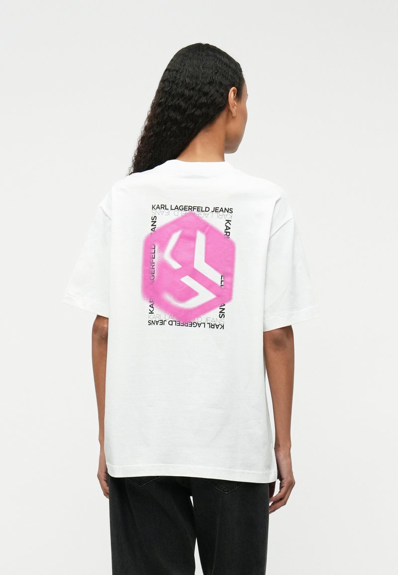 Λευκό βαμβακερό t-shirt με ροζ εξάγωνο γραφικό που διαθέτει λογότυπο και κείμενο "KARL LAGERFELD JEANS" εκτυπωμένο στην πλάτη. Κοντά μανίκια.