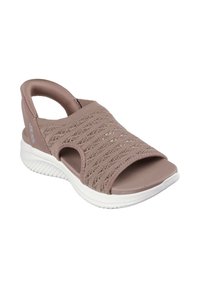 Sandalias de punto color malva con punta abierta, diseño de tiras anchas y suela texturizada blanca. Cuentan con cierre elasticado para facilitar su uso.