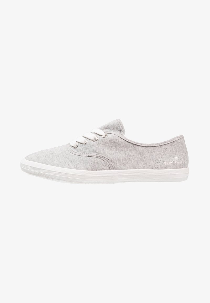 Baskets décontractées gris clair avec lacets blancs et semelle en caoutchouc blanche, vues de côté sur fond blanc.