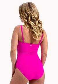 Fuchsia badpak met verstelbare spaghettibandjes, geplooide details op de rug en een klein metallic logo accent.