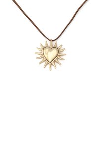 Pendentif en forme de cœur en or avec un motif de rayons de soleil sur un collier en cordon marron sur fond blanc.