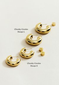 Chunky gold Creole-Ohrringe in großen und kleinen Größen mit einer glatten, glänzenden Oberfläche. Enthält zwei zusätzliche kreisförmige Teile.