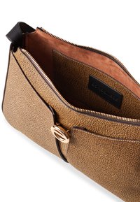 Brown textured faux leather bag with a gold zipper, an interior lined in tan fabric, and a metallic hardware accent on the front.