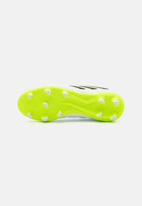 Suela de bota de fútbol, con una combinación de colores blanco y un vibrante amarillo neón, superficie texturizada y múltiples tacos blancos para tracción.