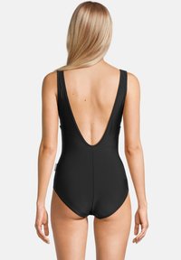 Maillot de bain une pièce noir avec un dos décolleté, des bretelles larges et une texture douce. Aucun motif ni matériel visible.