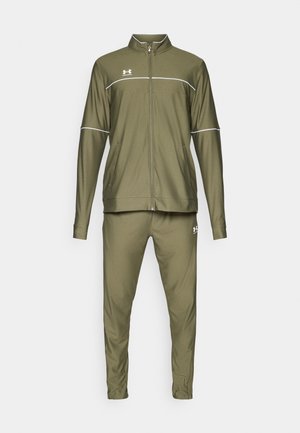 Chándal deportivo de color verde oliva que incluye una chaqueta con cremallera y detalles en blanco, junto con pantalones a juego; fabricado en un tejido suave y ligero.