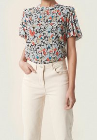 Kortärmad blommig topp i grått, med ett flerfärgat blommönster med röda, blå och beige accenter. Mjuk tyg med en avslappnad passform.
