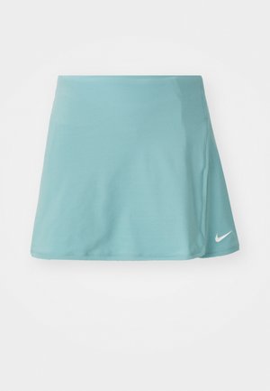 Falda atlética de color azul claro, fabricada con un tejido suave y elástico. Presenta una abertura lateral y un pequeño logo blanco de Nike en la parte inferior frontal.