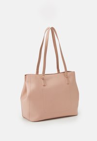 Sac fourre-tout rose en simili cuir texturé, doté de deux longues anses et d'une poche avant, avec des accents en métal doré.