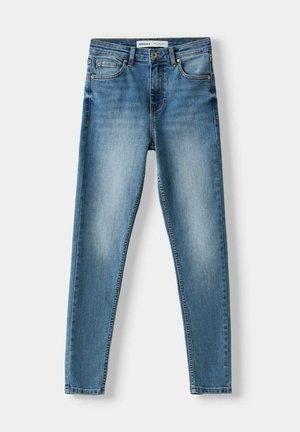 Blue denim skinny jeans featuring five pockets, a zip fly, and a worn-in look with light fading down the front and distinct stitching.