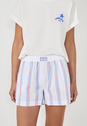 Pantaloni corti bianchi con strisce verticali rosse e blu, dotati di una cintura elastica e di una piccola toppa con logo sul davanti.