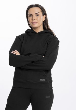 Must musta pehmeast kangast, millel on eesmine tasku, soonikkoes varrukad ja allserv. Logotempel alumises servas. Sobib koos vastava musta pükstega.