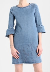 Denimmekko, jossa on pyöreä pääntie, kolmivartaloiset kellohihat, kirjailtu kukkakuosi helmassa ja vaaleansiniset värit.