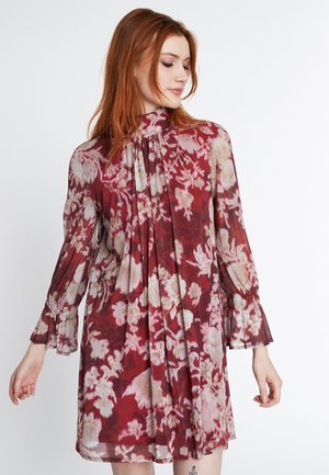 Durchsichtiges, floral gestaltetes Minikleid in Rot mit weißen und rosa Mustern, gerafftem hohen Ausschnitt und weit ausgestellten Ärmeln mit elastischen Bündchen.