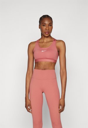 Sujetador deportivo rosa con un logo blanco, combinado con leggings de cintura alta a juego. Textura suave y diseño ajustado para uso activo.