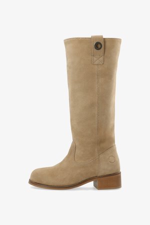 Bežīgas zamšādas ceļa augstās zābaki ar apaļu purngalu, koka bloku papēdi un dekoratīvu pogu netālu no augšas.