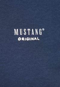 Marineblaue Baumwoll-T-Shirts mit dem weißen Drucktext "MUSTANG® ORIGINAL" auf der Vorderseite, glatte Textur und taillierte Passform.