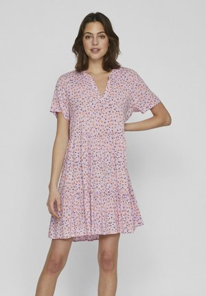 Vestido floral rosa con mangas cortas, escote en forma de V y falda de volantes. Presenta pequeñas flores naranjas y moradas sobre una tela ligera.