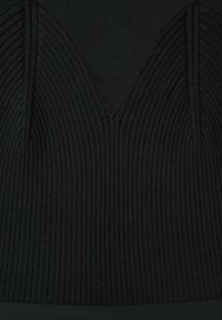 Primer plano de tela de punto negra con costillas, con un patrón estructurado y contorneado en forma de V en el centro.