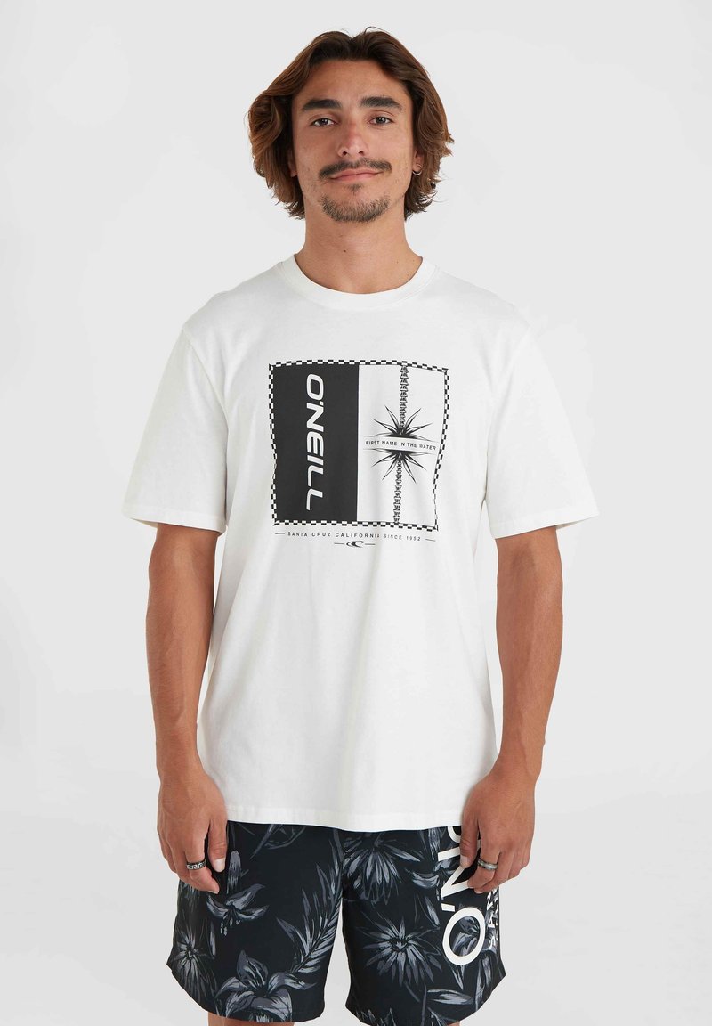 Hvid bomulds t-shirt med et centralt grafik med sort-hvide mønstre, herunder tekst og et stjernedesign, parret med sorte blomstrede shorts.