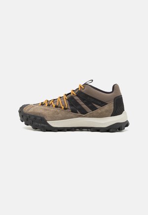 Scarpe da trekking con tomaia in suede e tessuto marrone e nero, lacci arancioni e suola in gomma testurizzata per una migliore trazione.