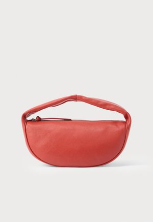 Punainen puolikuun muotoinen käsilaukku, jossa on pehmustettu kahva ja yläreunassa vetoketjusuljenta valkoisella taustalla.