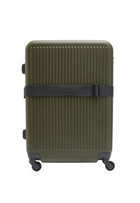 Oliwkowa, twarda walizka z pionowymi rowkami, czarny pasek do bezpiecznego zamknięcia oraz cztery kółka ułatwiające mobilność.