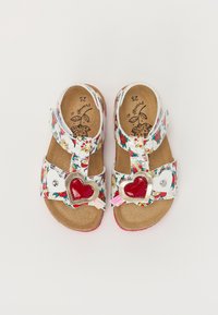 White sandals with floral pattern, red heart-shaped accents, and adjustable straps. Cork footbed with a textured finish. Size 25.