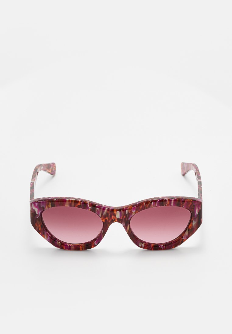 Różowe okulary przeciwsłoneczne w kocim kształcie, z lśniącym wykończeniem i gradientowymi soczewkami przechodziącymi od jasnoróżowego do ciemnoróżowego.