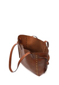 Borsa a tote in pelle marrone con una texture morbida, caratterizzata da borchie in ottone sui lati e un ampio interno aperto. Include una tracolla regolabile.