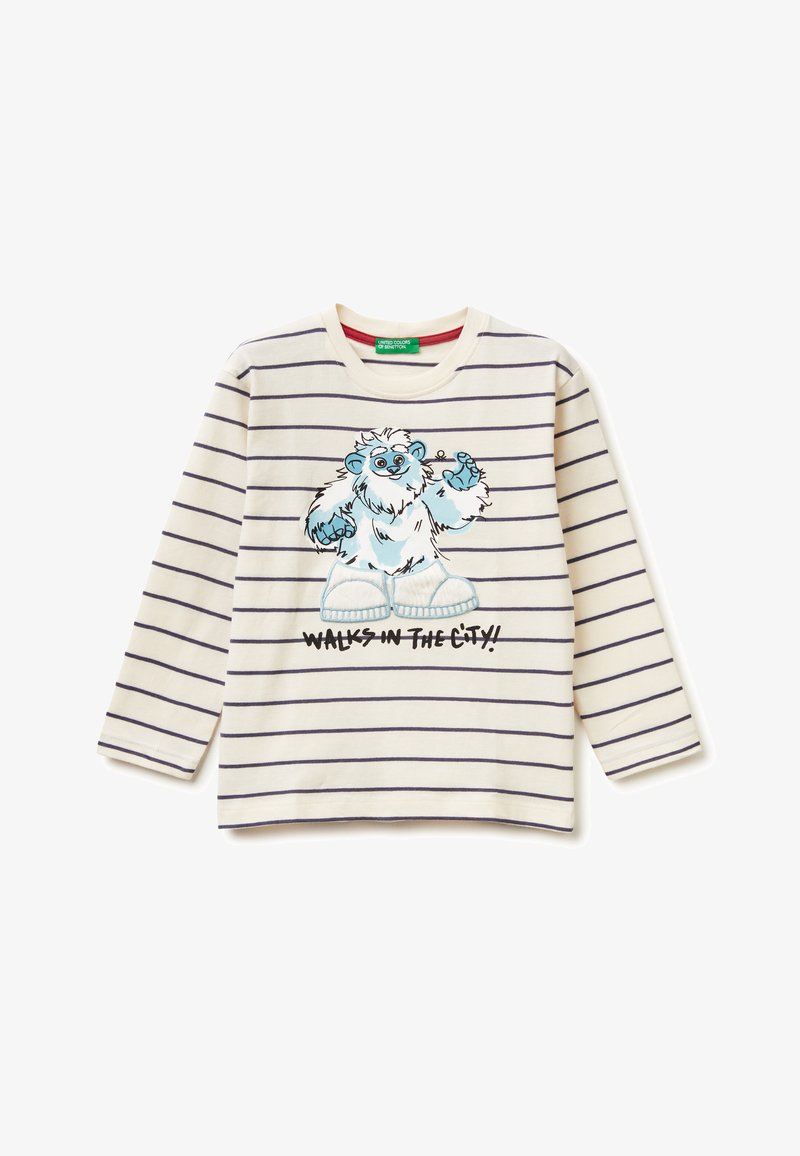 Bavlněná košile s dlouhým rukávem v krémových a námořnických pruzích, na které je vyobrazen modrý medvěd s nápisem "VYZKOUŠENÍ VE MĚSTĚ!" vytištěným pod ním.