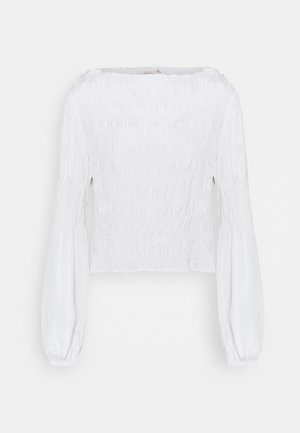 Weiße Bluse mit gerafftem Oberteil, langen Puffärmeln und weitem Ausschnitt. Glatte Textur mit Raffungselementen im gesamten Stoff.