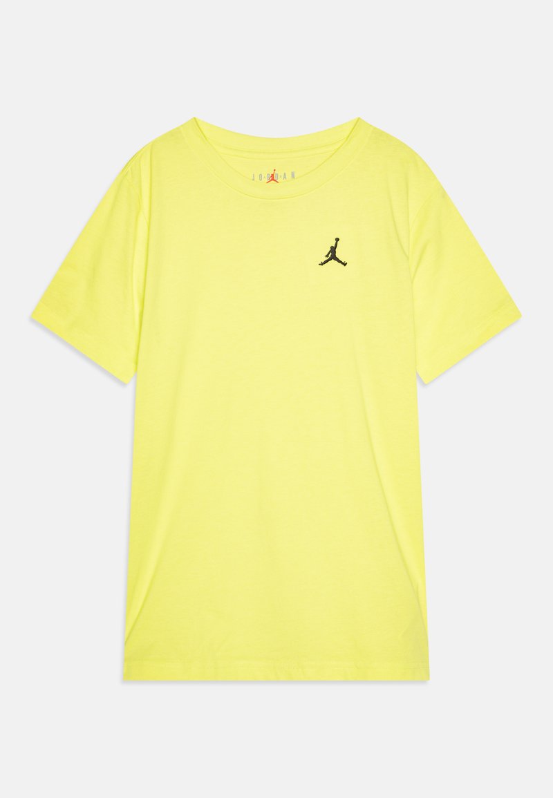Camiseta de algodón amarilla brillante con cuello redondo, manga corta y un logo negro de Jordan en el lado izquierdo del pecho. Textura suave, diseño casual.