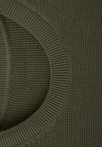 Gros plan sur un tissu tricoté vert olive montrant un col rond côtelé et un motif de couture texturé.