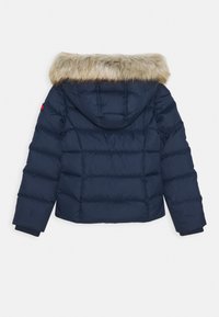 Giacca puffer blu navy con cappuccio foderato in pelliccia, caratterizzata da un design trapuntato e polsini a costine, che offre calore e isolamento.