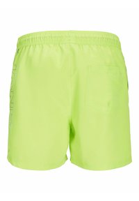 Bañadores verdes neón con cintura elástica, que cuentan con un bolsillo trasero y un sutil estampado de logo en el lateral. Textura suave, material ligero.