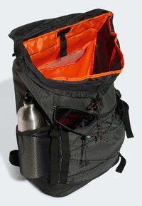 Black fabric backpack with orange interior lining, side mesh pockets for water bottle and sunglasses, and multiple storage compartments.
