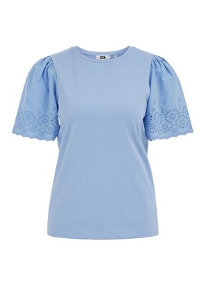 Chemise bleu clair à manches courtes bouffantes avec broderie florale en dentelle ajourée et bords festonnés, col rond.