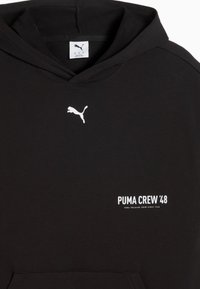 Μαύρο φούτερ με κουκούλα Puma με λευκό λογότυπο Puma στο κέντρο του στήθους και το κείμενο "PUMA CREW '48" στη δεξιά κάτω πλευρά.