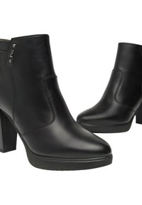 Un paio di stivaletti neri in pelle con tacco a blocco e cuciture lisce, dotati di un piccolo dettaglio metallico vicino al bordo superiore.