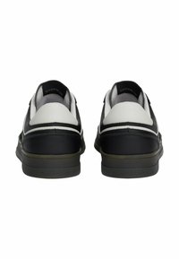 Czarno-białe skórzane sneakersy o gładkim wykończeniu, zaokrąglonym kształcie, wyściółce przy kołnierzu i detalu z logo na pięcie.