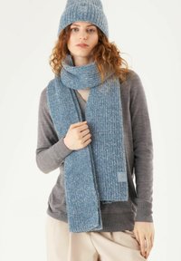 Blue knit scarf in a ribbed pattern, made from textured material, paired with a matching beanie. Features a small logo label on the scarf.