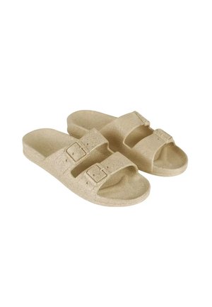Paar beige open-toe slides met twee verstelbare gespsriemen en een gestructureerd voetbed, ontworpen voor casual gebruik.