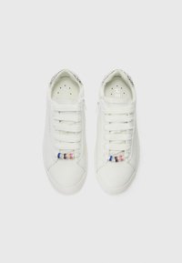 White sneakers with a smooth texture, featuring lace-up closure, decorative bead accents in blue, pink, and gold on the toe area.