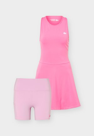 Rosa ermeløs sportkjole med utvidet skjørt og matchende lyserosa høytlivs treningstights, begge sømløse og tettsittende.