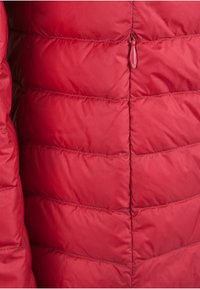 Veste isolante rouge avec un design matelassé présentant des coutures horizontales, une texture lisse et une fermeture éclair au niveau du col.